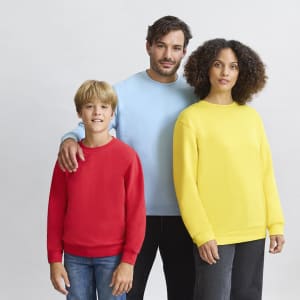 Three individuals wear colourful sweatshirts: a red one, a light blue one, and a bright yellow one. The group has a relaxed pose.