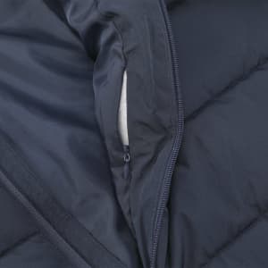 A close-up of a navy blue puffer jacket's interior, featuring a zippered pocket and soft lining.