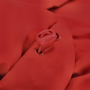 A close-up of a red puffer jacket featuring a toggle and drawstring design. It has a logo present.