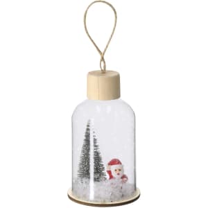 A decorative snow globe featuring a Santa figure and trees, enclosed in a clear dome with a wooden base and hanging cord.
