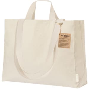 A large beige tote bag with two handles and a tag, made from recycled materials. It also features a logo.