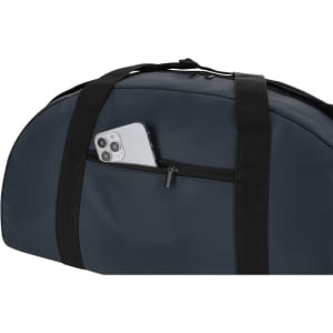 A navy tote bag with a zippered pocket featuring a smartphone tucked inside. It has black straps and a sleek design.