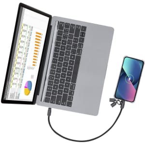 A grey charging cable connects a laptop to a smartphone, with a spreadsheet displayed on the laptop screen.