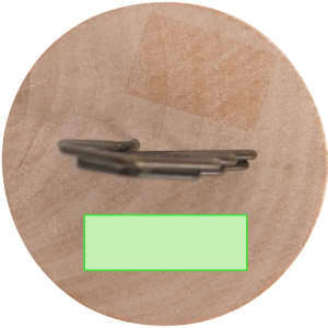 A wooden clip with a metal clasp, featuring a round base and a smooth surface. The product has a simple design.