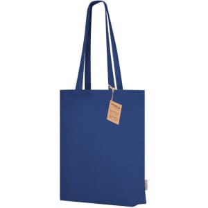 A blue tote bag with long straps and a small tag attached. It features a branding logo.