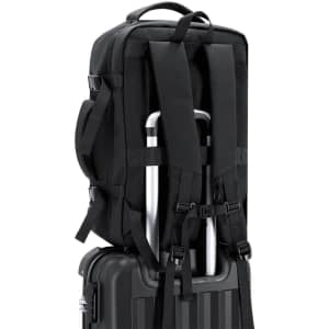 A black Forin Backpack with adjustable straps, positioned on top of a wheeled suitcase.