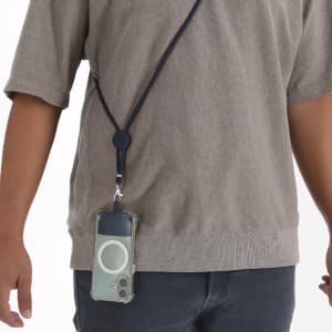 A navy lanyard holds a clear phone case, hanging from a person’s neck. The lanyard features a sliding adjuster.