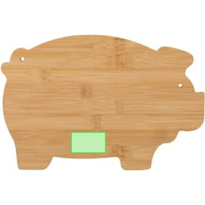 A bamboo cutting board shaped like a pig, featuring a green accent. It also has a small logo.