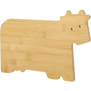 A bamboo chopping board shaped like a cow, featuring a natural wood finish and a simple design.