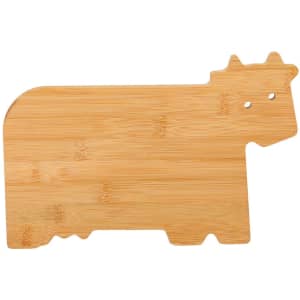 A bamboo cutting board shaped like a cow, featuring a natural wood finish and a playful design.