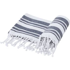 A striped grey and white towel, featuring fringed edges, rolled and partially unfolded.
