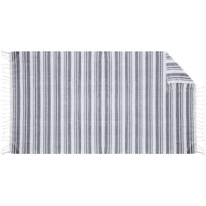 A striped grey and white towel with fringed edges, suitable for beach or bath use.