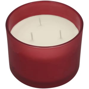 A red glass candle holder featuring a white three-wick candle inside.