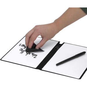 A white notepad whiteboard with a black trim, featuring a hand erasing text and a black pen nearby.