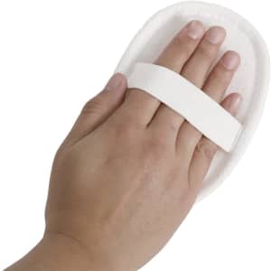 An exfoliating sponge in white held by a hand, featuring a soft strap for easy grip.
