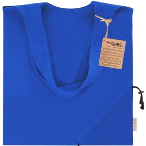 A foldable tote bag in bright blue with a natural fabric tag, featuring a logo. Made from recycled cotton.