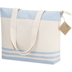 A tote bag featuring a blue and cream design with striped accents and long handle straps. It has a logo on it.