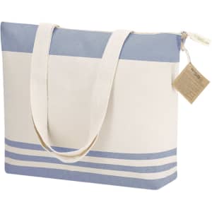 A tote bag featuring a light blue and cream design, with two sturdy handles and a zip closure. It has a branding tag attached.