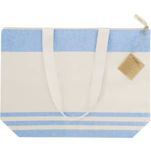 A tote bag featuring a cream and light blue design, with a zipper and two sturdy handles. It includes a tag and logo.