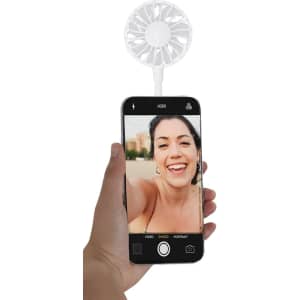 A handheld phone with a white fan attachment, displaying a smiling person on the screen.