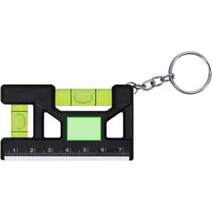 A black bubble level keyring with green accents and a small ruler, attached to a metal chain.