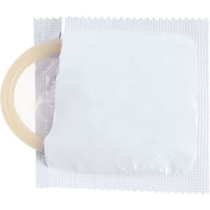 A condom partially visible in a sealed foil wrapper, featuring a neutral colour. The wrapper has a logo design.
