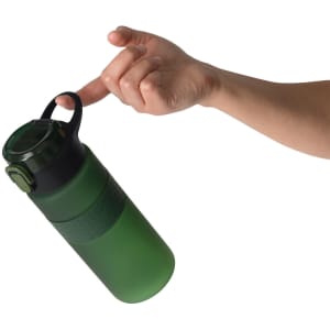 A drink bottle in shades of green with a black lid, held by a hand using the carrying handle.