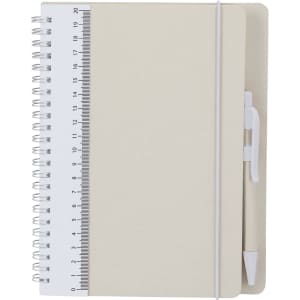 A spiral-bound Kirax notebook in cream, featuring a ruler on the front cover and a white pen attached.