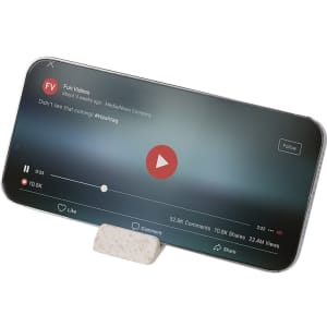 A smartphone propped up on a textured white holder, displaying a video playback screen.