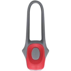 A grey and red bike safety light with a sleek, modern design and a circular button on the front. It has a logo.