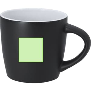 A black matte coffee mug with a green square on the side and a white interior. It features a curved handle.