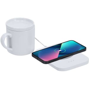 A drink bottle and a smartphone on a white wireless charger, with a white mug nearby.