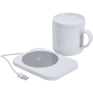 A white drink cup next to a white wireless charger with a USB cable, featuring a sleek design.
