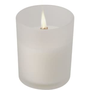 A frosted white jar candle with a lit wick, featuring a minimalistic design and soft glow.