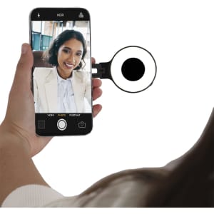 A smartphone with a mounted ring light, positioned for taking photos, featuring a black and white design.