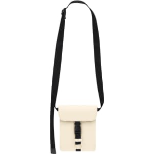 A light cream shoulder bag with a black strap and a front buckle closure. It features a minimalist design.