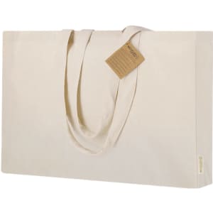 A large cream tote bag with two handles and a tag attached. It features a branding logo.