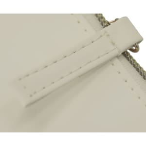 A close-up of a cream toiletry bag featuring a zip closure and a leather-like tab. The bag has a subtle sheen.