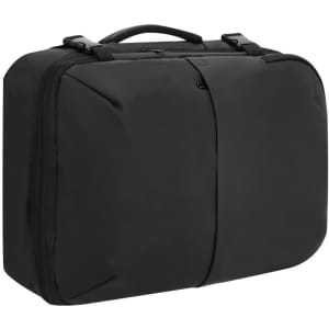 A black vacuum backpack with dual zippers and a handle, featuring a sleek and modern design.