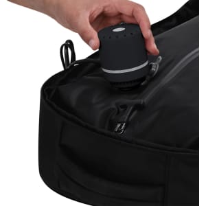 A black vacuum backpack with a hand holding a small vacuum pump, featuring a sleek design and integrated zipper.