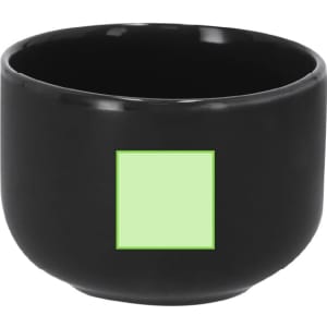 A black coffee mug with a square design space in light green. The mug has a glossy finish and a round shape.