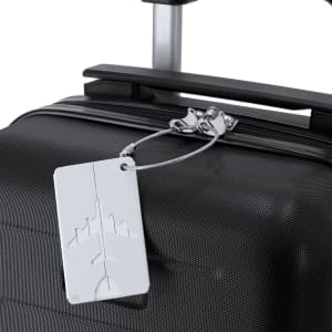 A luggage tag in white attached to a black suitcase, featuring a design with an airplane motif and a branding logo.