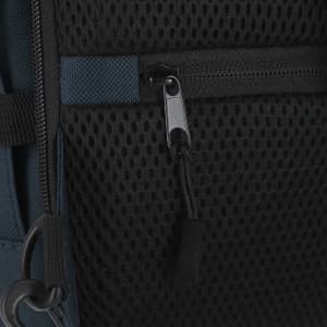 A close-up of the Zagros Backpack featuring a mesh pocket and a zipper pull, in navy blue and black colours.