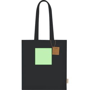 A black tote bag featuring a square green patch and a tag, showcasing a simple and stylish design.