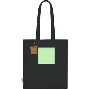 A black tote bag featuring a green square detail and a tag. The bag has sturdy handles for easy carrying.