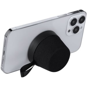 A black Dinarix speaker attached to the back of a white smartphone. The speaker has a simple design with a strap.