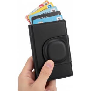 A black business card holder with credit cards partially visible, held in a hand.