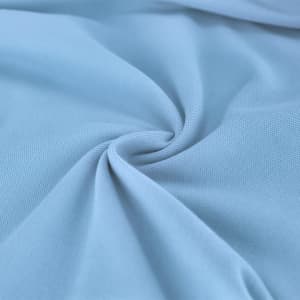 A close-up of light blue fabric featuring a smooth texture and gentle folds. It has an overall soft appearance.