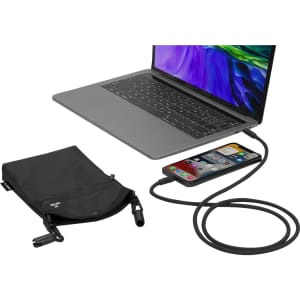 A black multipurpose bag is displayed next to a laptop and a smartphone connected by a charging cable. The bag has a logo.