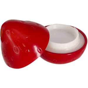 A red strawberry-shaped lip balm container with a removable top, revealing the white balm inside.